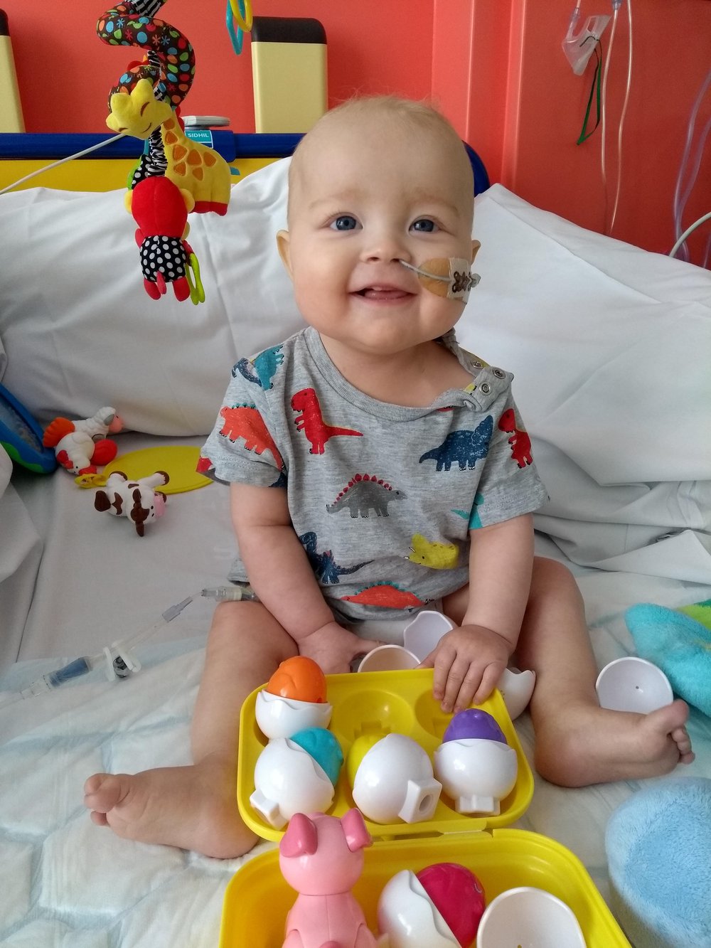 A little boy smiling on a bed
