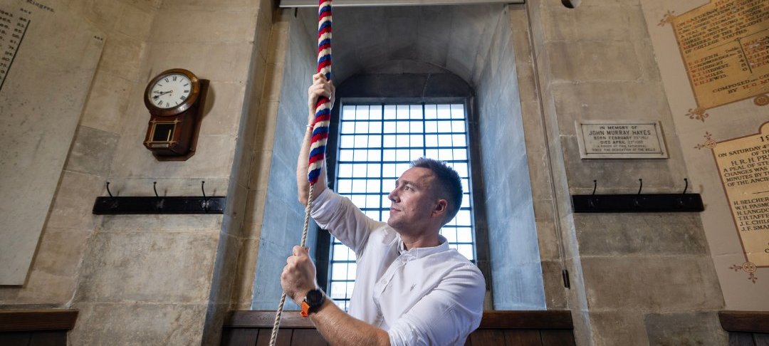 Man ringing bell inside cathedral