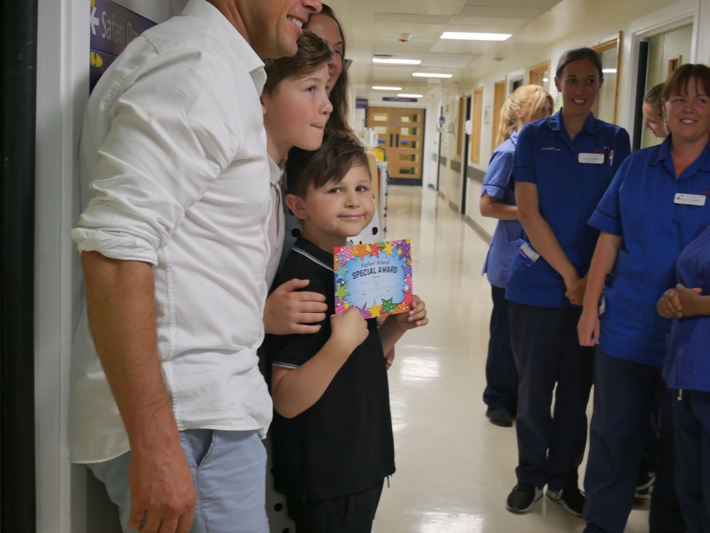A young boy standing on a hospital ward