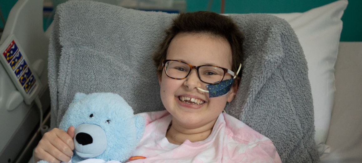 Alyssa in bed at GOSH smiling to camera