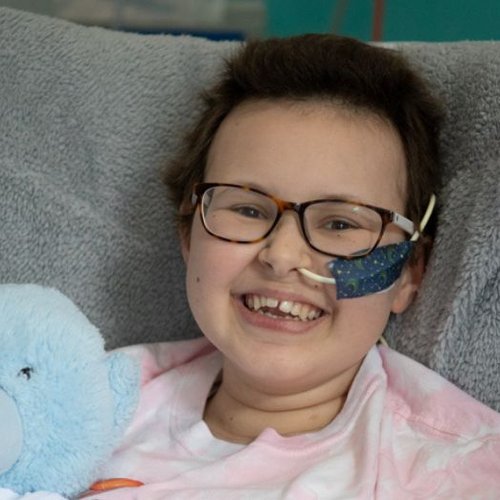Alyssa in bed at GOSH smiling to camera