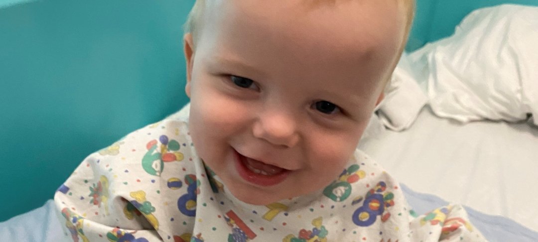 Arlo sitting on hospital bed and smiling to camera