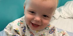 Arlo sitting on hospital bed and smiling to camera