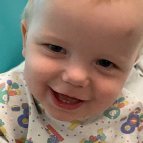 Arlo sitting on hospital bed and smiling to camera