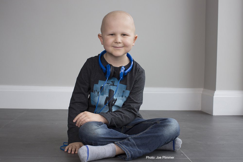 A little boy sitting cross legged on the floor