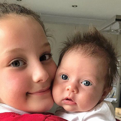 A little girl holding a baby
