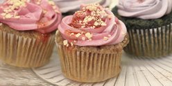 Four cupcakes with pink and purple icing