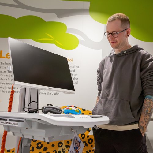 DanTDM smiling and standing next to a cart from TheRockinR Gaming Charity
