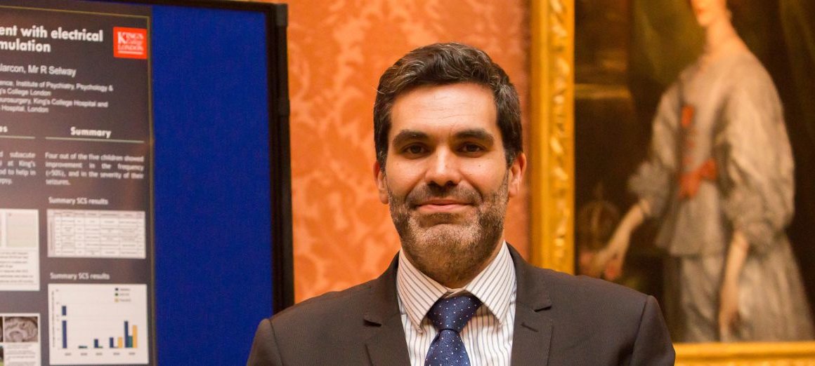 Headshot of Dr Antonio Valentin wearing a suit and smiling to camera.