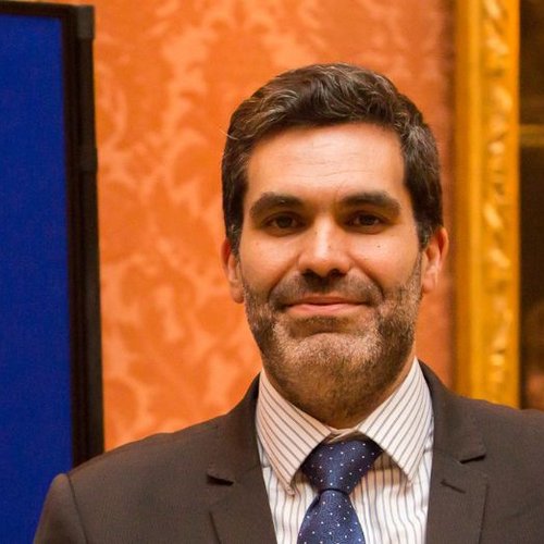 Headshot of Dr Antonio Valentin wearing a suit and smiling to camera.