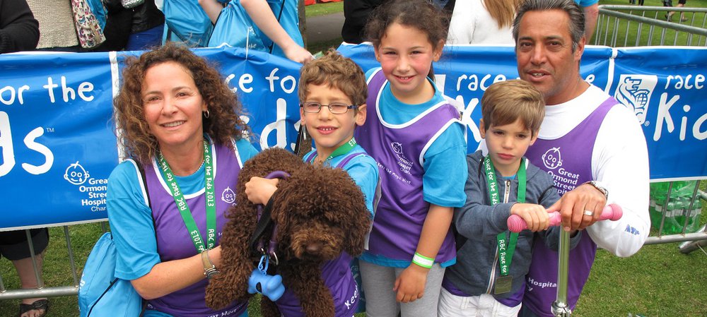 A woman, man, three children and a dog pictured at outdoor event, smiling to camera.