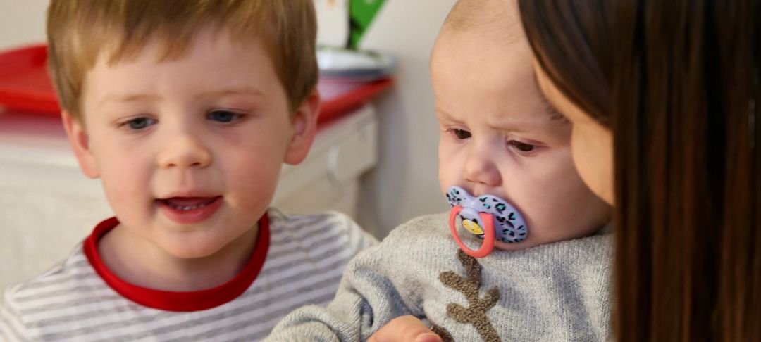 Baby Emmie at GOSH during Christmas, with her brother and mum.
