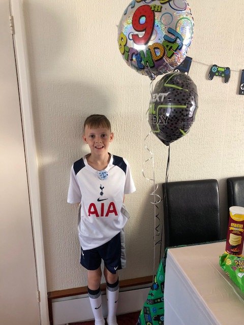 Boy on his ninth birthday in front of a balloon