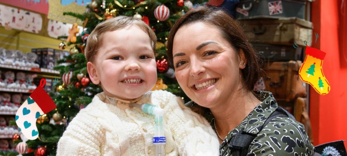 Patient Henry and his mum Shevonne in front of a Chistmas tree