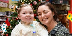 Patient Henry and his mum Shevonne in front of a Chistmas tree