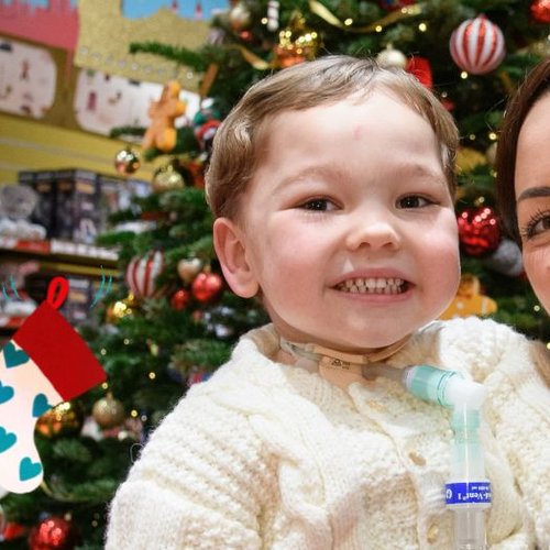 Patient Henry and his mum Shevonne in front of a Chistmas tree