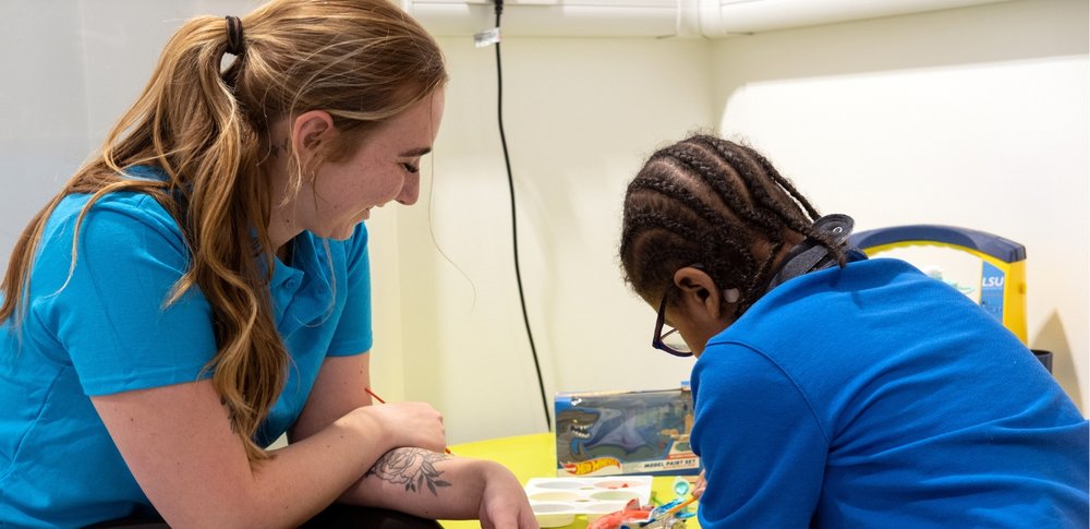 Play Specialist Jade and GOSH patient Nathan are painting.