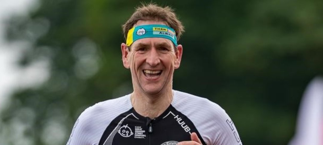 Headshot of man running and smiling