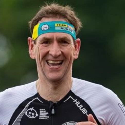 Headshot of man running and smiling