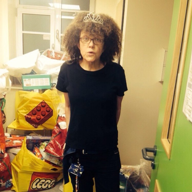 Lizzie standing in front of Christmas presents for patients at GOSH
