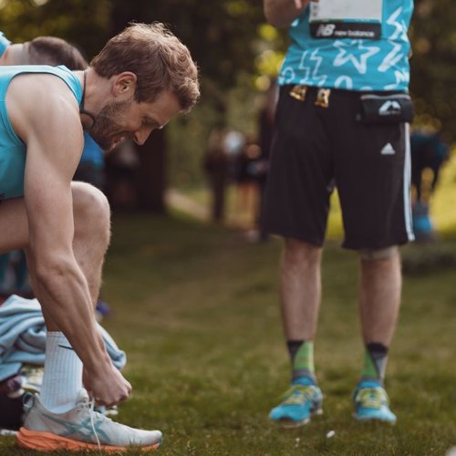 London Marathon runner tying shoelaces before the event