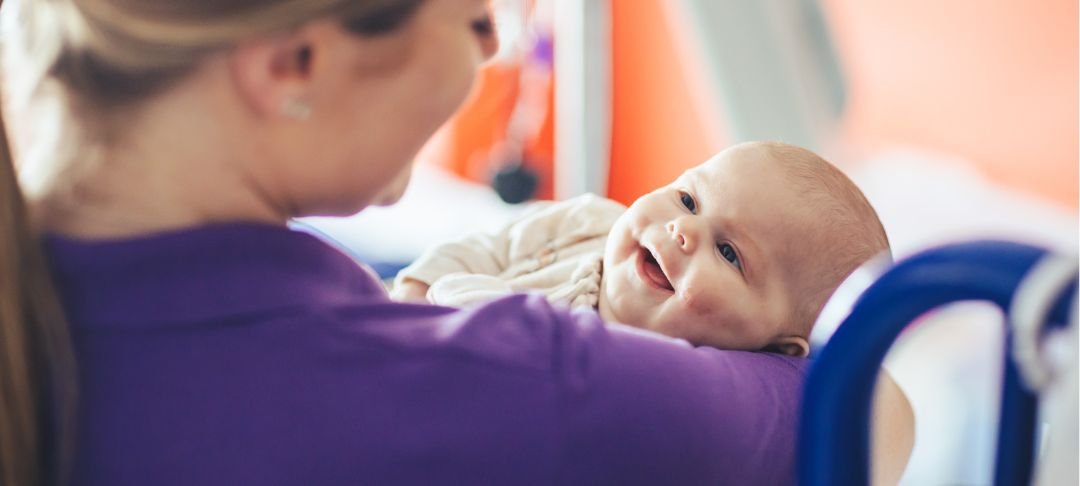 Maya looking at GOSH Play Specialist and smiling