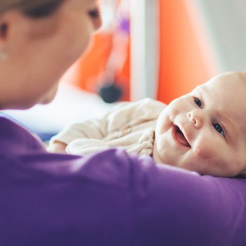 Maya looking at GOSH Play Specialist and smiling