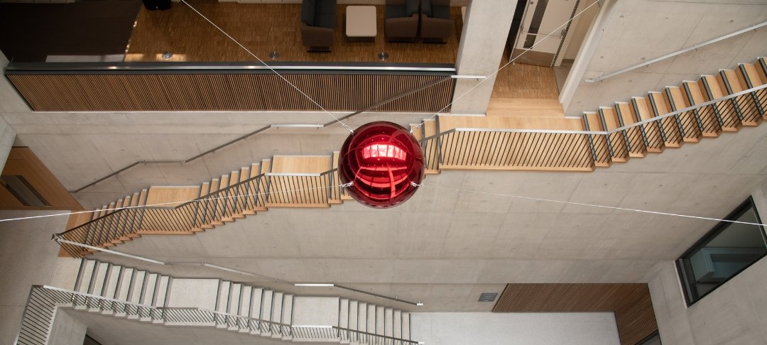 A red sphere, which is a moving sculpture, inside the Zayed Centre for Research