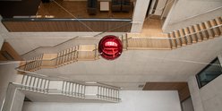 A red sphere, which is a moving sculpture, inside the Zayed Centre for Research