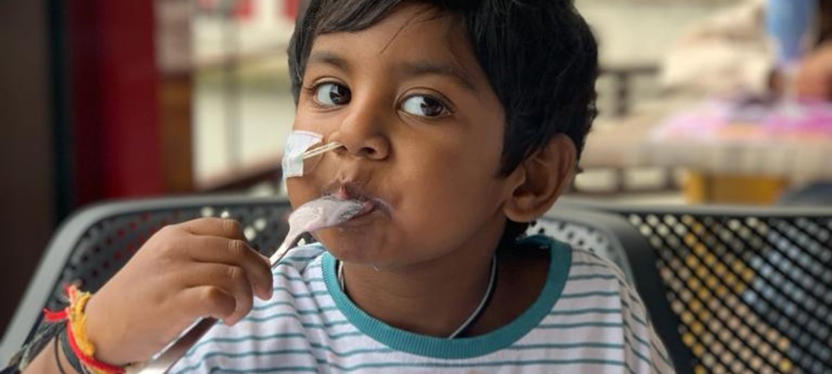 Little boy sitting outside eating ice cream