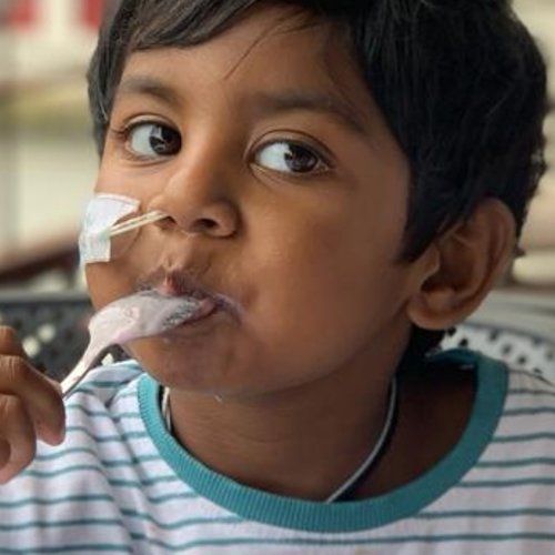 Little boy sitting outside eating ice cream