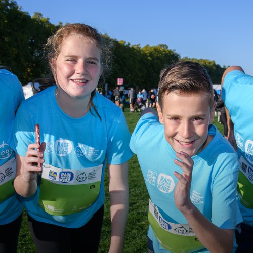 A mother, daughter, son and father smile at the camera and pose like they are about to start Race for the Kids.