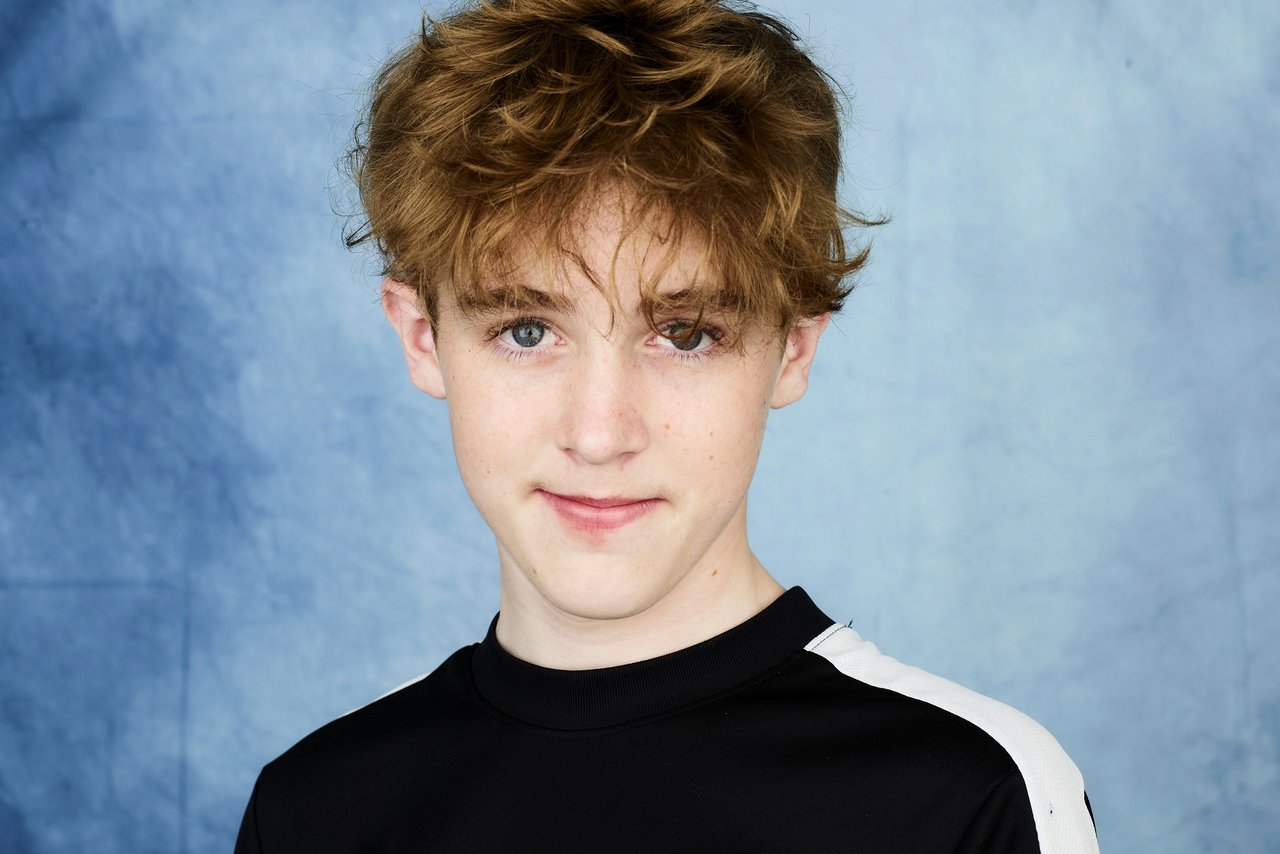 Portrait of GOSH patient Eamonn by photographer Rankin. Eamonn is wearing a black long sleeved top and is slightly smiling to the camera.