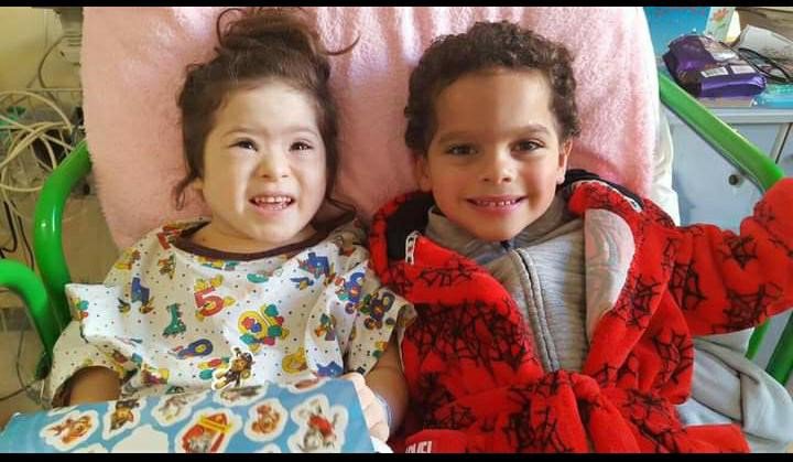 Patient, Grace in a hospital bed with her twin brother, Max