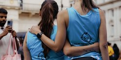 Two runners with their arms around each other, wearing GOSH Charity vests.