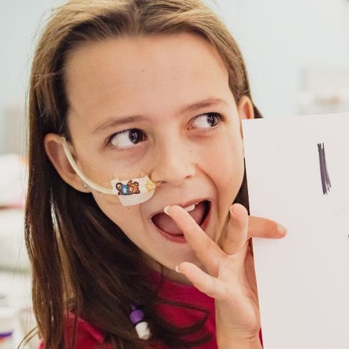 Photo of Sophia smiling and holding a sign reading "I passed my 11+".