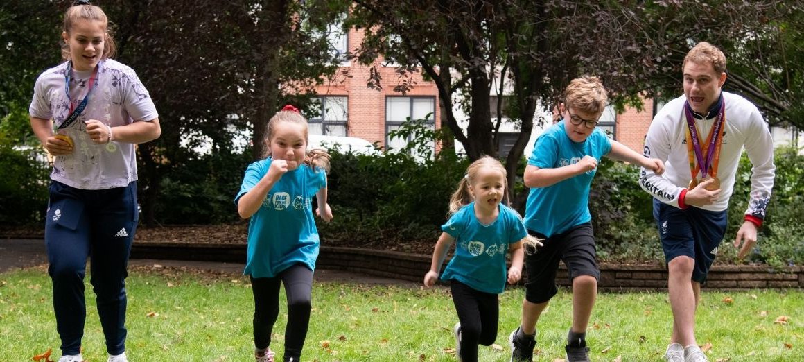 three GOSH patients run alongside two sporting heroes outside