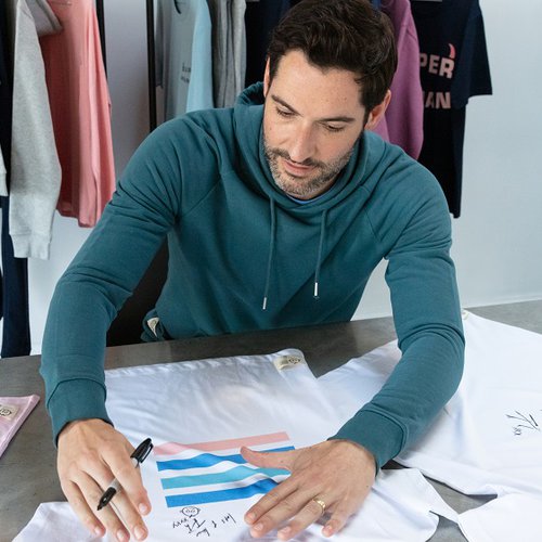 Tom Ellis signs a selection of clothes from the Rupert and Buckley collection