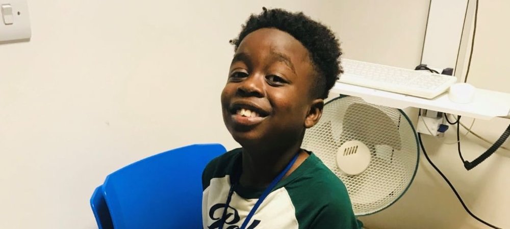 Headshot of Gabriel smiling and sitting on a chair in a room at GOSH