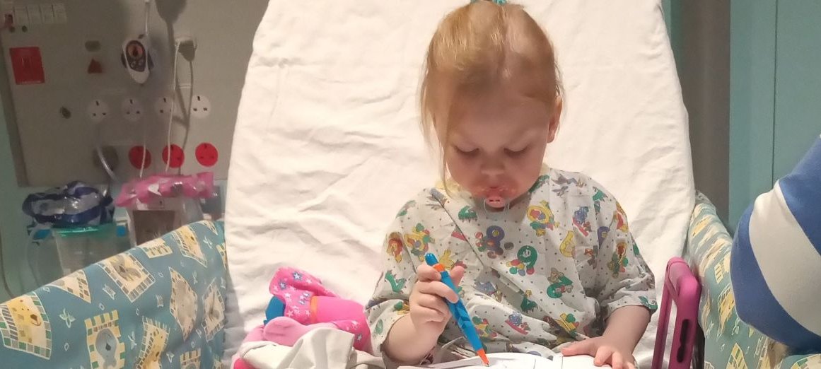 Marnie sitting in bed at GOSH reading