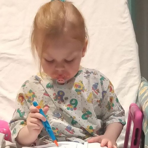 Marnie sitting in bed at GOSH reading