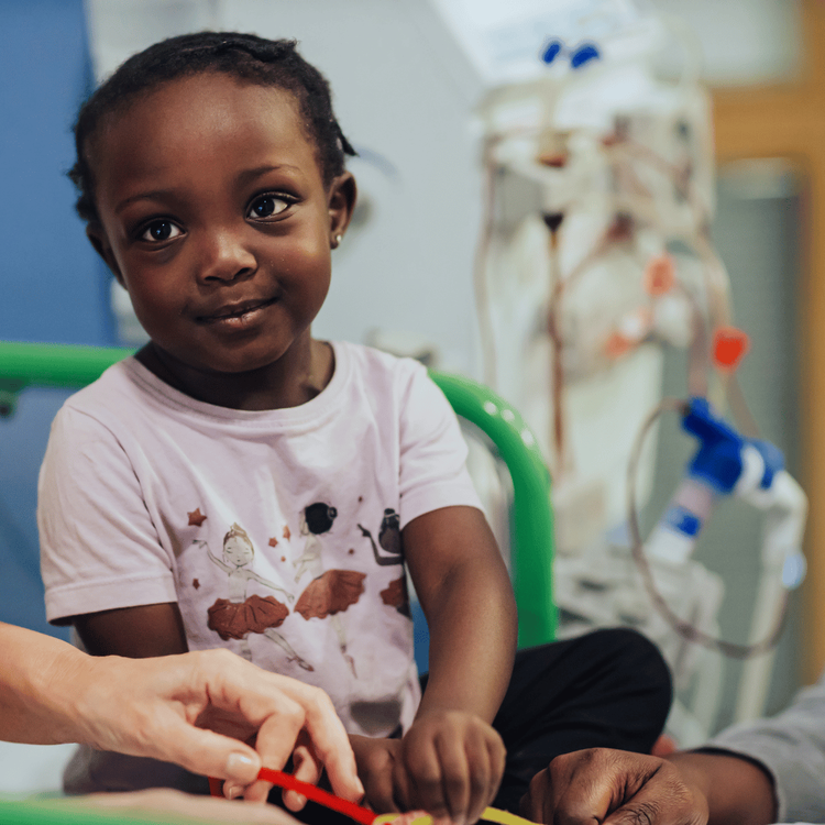 Destiny-Rae when she was younger, sitting on her bed at Great Ormond Street Hospital.