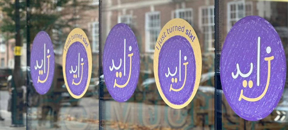 ZCR logo on vinyl stickers on window outside the ZCR building. Some stickers read "I just turned six".