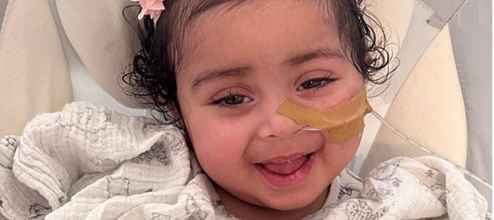 Little girl with tube in nose smiling to camera